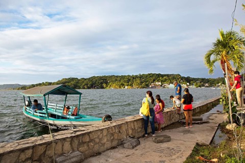 Guatemalans and a boat on the shore, Lake Petén Itzá in Flores, Petén Department, Guatemala