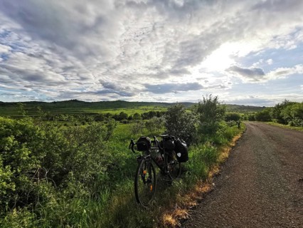 Bicycle along a rural trail with vast green fields and dramatic skies, Czech Republic
