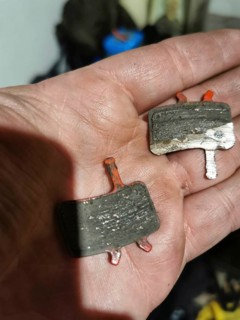 Close-up of used brake pads on one hand, bicycle, disc brakes, worn