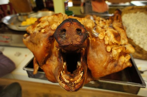 A roasted pig's head (porcus) with a crispy crust in a rustic restaurant, Ecuador