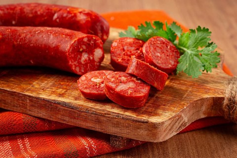 Spicy Chorizo sausage, on a cutting board, on a wooden table