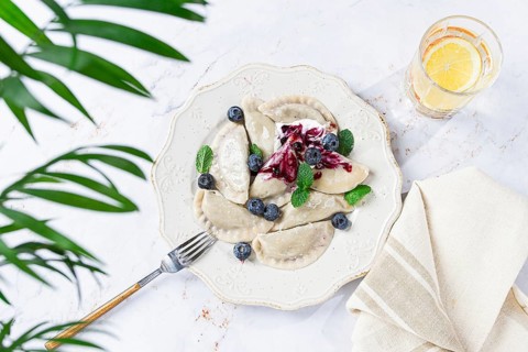 Handmade dumplings filled with sweet ingredients, arranged beautifully on a white plate, topped