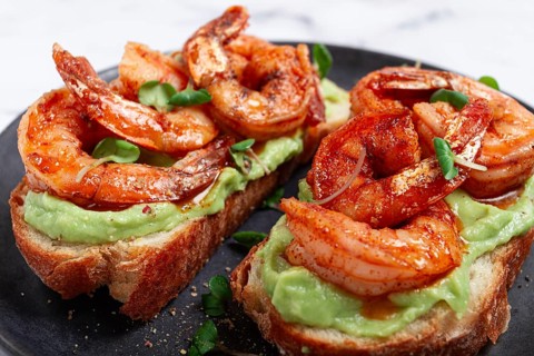 Sandwiches with avocado and caramelized shrimp, micro-greens, breakfast, on a plate, top view,