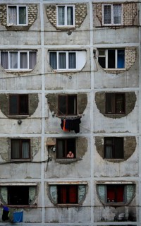 A prefabricated building with symmetrical windows and visible decay that conveys a melancholy urban