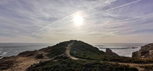 A trail leads over a hill, the sun shines over the coast, Southwest Alentejo nature park Park and
