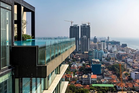 Urban view with modern high-rise buildings and a pool on the edge of a building with sea views