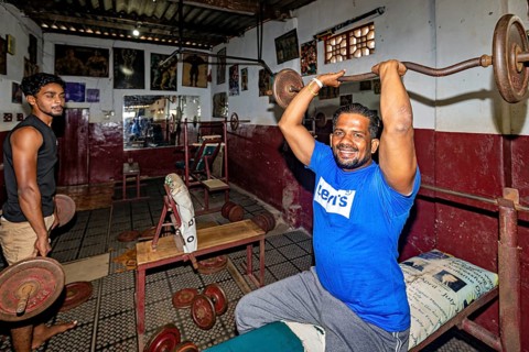 Men weightlifting in a traditional gym with rustic charm