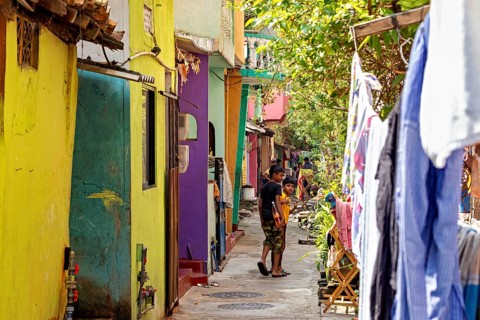 Colourful alley with children playing and hanging clothes, lively and warm