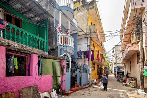 Colourful residential buildings on a busy urban street with passers-by