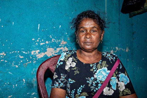 Portrait of a woman in front of a blue, peeling wall in an interior