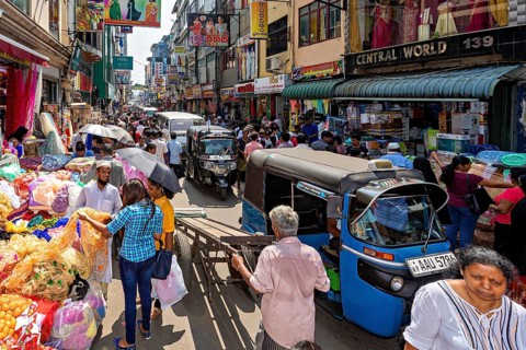 Busy street with market stalls, people and rickshaws in a busy shopping district, the hustle and