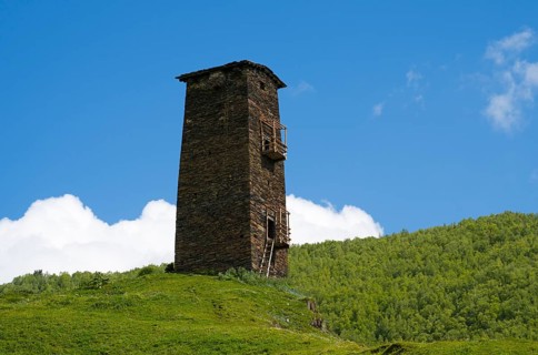 Single old tower on hill with green landscape and cloudy sky, Queen Tamar's tower, Tamara, Ushguli,