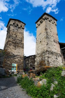 Two old stone towers under a blue sky with clouds, defensive towers, Ushguli, Ushguli, Shibiani