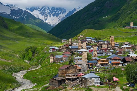 Picturesque village with many towers and houses in a green mountain valley, defensive towers,