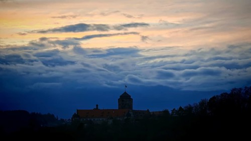 Castle silhouette against dramatic sunset sky, calm and mystical atmosphere, Rosenberg Fortress,