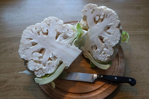 Halved cauliflower (Brassica oleracea var. botrytis) on a wooden board, Bavaria, Germany