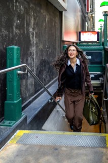 Young businesswoman with a confident smile and flowing hair, carrying a professional bag and a