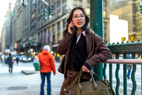 Young businesswoman in manhattan walking and talking on a smartphone, dressed smart casual,