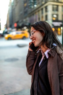 Young female executive communicating on a mobile phone, smiling and engaging in a casual