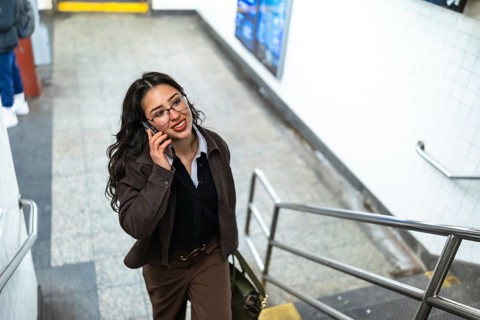 Young businesswoman with glasses and a professional outfit talking on a mobile phone while