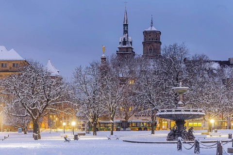 Winter in Stuttgart. The city is wintry white early in the morning. Castle square with fountain and