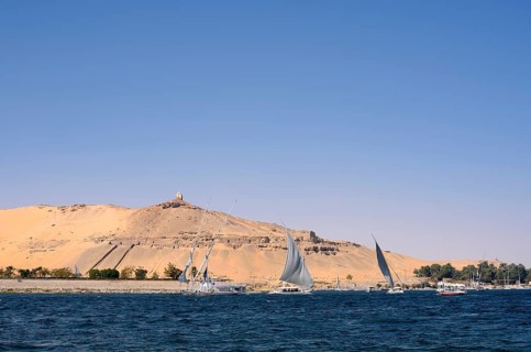 Qubbet el-Hawa with the rock tombs on the Nile, Aswan, Egypt