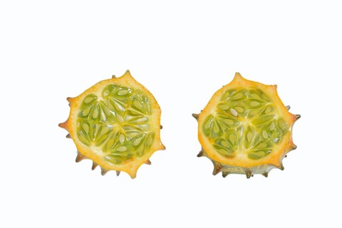 Horned cucumber, kiwano or horned melon (Cucumis metuliferus), sliced fruit on a white background,