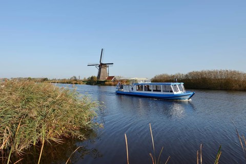 Historic windmill and sightseeing boat, UNESCO World Heritage Site, Kinderdijk, South Holland,