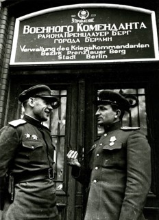Two Soviet soldiers in front of the administration of the war commander for the district of