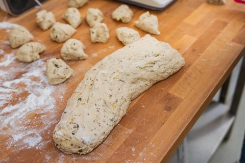 A large lump of dough together with pieces of dough on a wooden table, baking rolls, Haselstaller