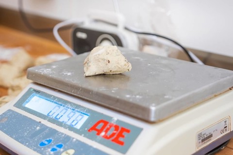 A piece of dough is measured on a digital scale in a bakery, bake rolls, Haselstaller Hof,