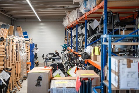 Storage room with shelves full of wheelchairs and boxes, industrial and organized, medical supply