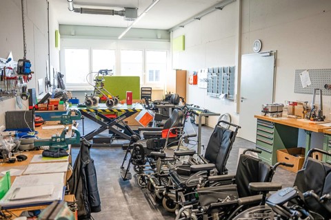 Workshop with wheelchairs and rehabilitation equipment, bright and functional atmosphere, medical