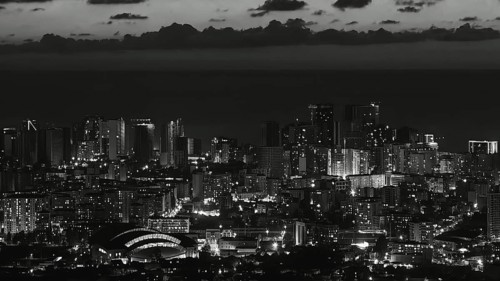 City view at night with illuminated skyscrapers and clouds in the sky in black and white, Batumi,