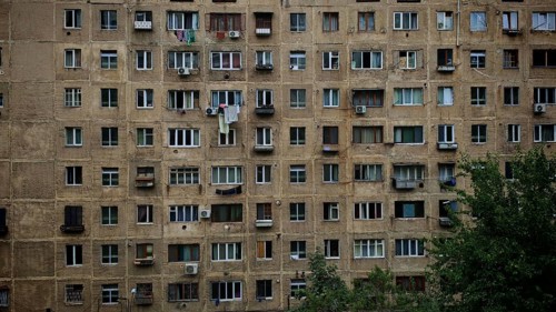 An old apartment block with lots of windows and balconies, surrounded by trees, Tbilisi, Georgia