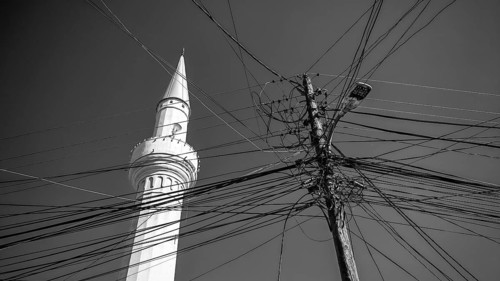 A minaret and numerous power lines against a monochrome sky, Prizren, Kosovo