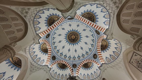 Detailed view of a richly decorated dome with blue and gold ornaments in Islamic architecture,