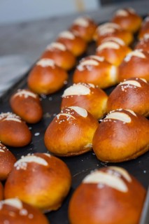 Golden brown pretzel rolls with salt spread in stripes on a baking tray, bake rolls, Haselstaller
