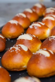 Fresh, golden brown pretzel rolls with salt streusel lie on a baking tray, bake rolls, Haselstaller