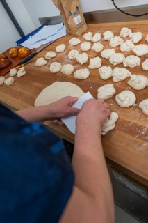 A baker kneads dough on a wooden work surface in the bakery, baking rolls, Haselstaller Hof,