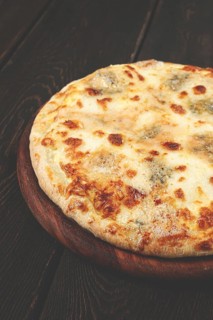 Freshly baked cheese pizza, with a golden crust and bubbling melted cheese, white pizza, on a