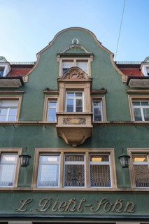 Historic building façade from the Wilhelminian period with green paint and decorative details,