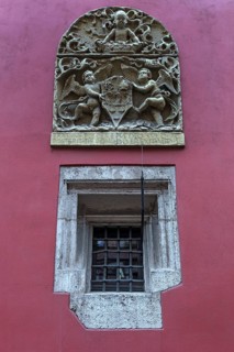 Relief with coat of arms and angels on a coloured house wall, Krakow, Poland