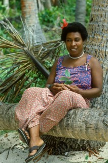 Woman (Katherina) sitting on a coconut trunk on the beach, Tavewa Island, Yasawa Islands, Fiji