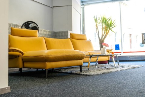 Modern living room with yellow sofa and window front, cozy atmosphere