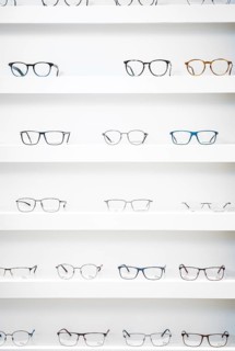 Several pairs of glasses neatly arranged on shelves in an optician's shop, optician, Pforzheim