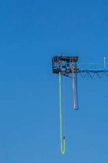 Montreal Bungee Tower installation with dangling long yellow elastic bungee jumping cord and woman