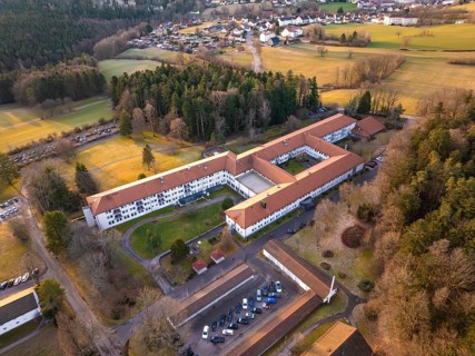 Building complex surrounded by fields in a rural village, from an aerial view, rehab clinic,