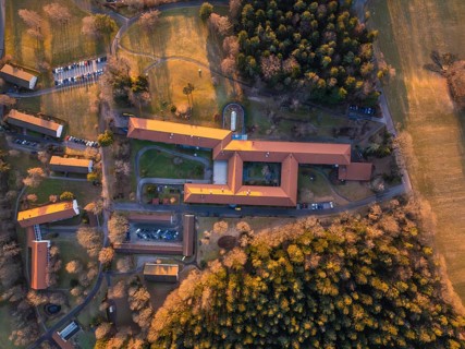 Bird's eye view of a sprawling complex with red roofs and forests, Rehab Clinic, Schömberg, Black