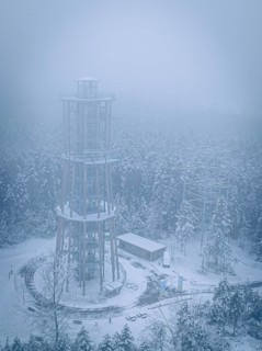 A foggy, snow-covered treetop trail rises in the winter landscape, Himmelsglück observation tower